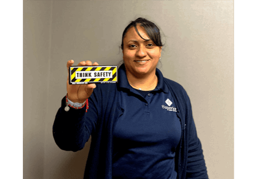 Karina Alvarez, plant operations manager, holding a safety candy bar that was passed out during Superior Linen Service's celebration cookout.